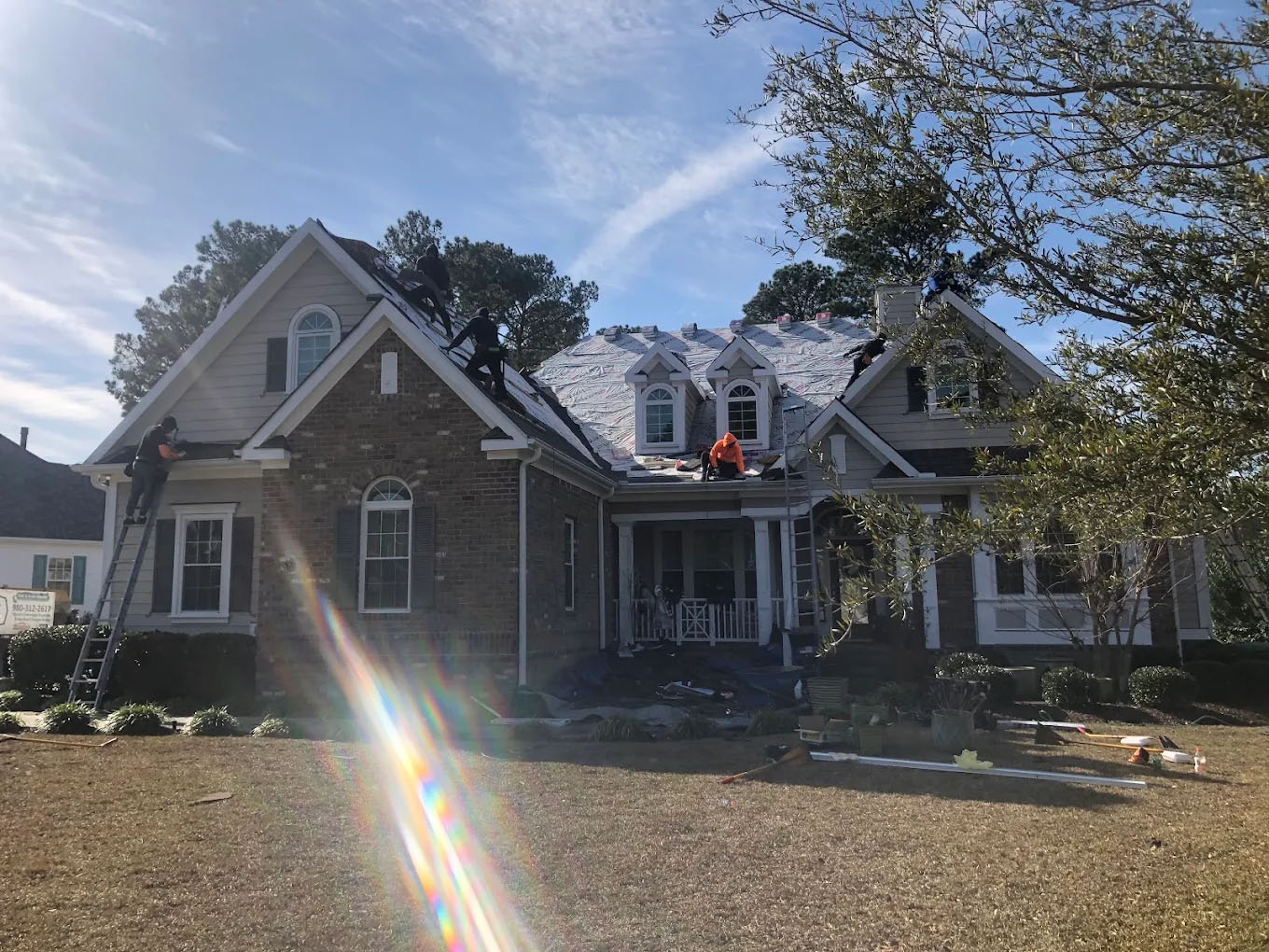 An EBS crew installing a new roof system on a brick home.